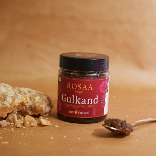 Jar of Rosaa Gulkand with a piece of gulkand and a spoon on a wooden surface